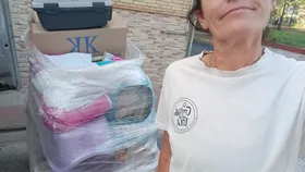 A volunteer next to bags of donated materials